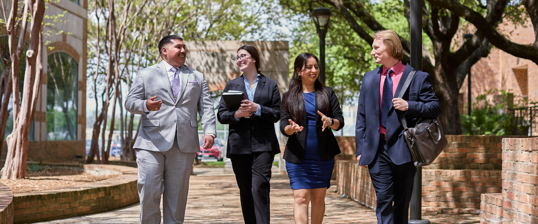 Four students walk together outside the law school