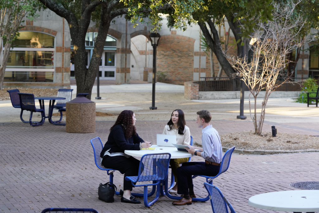 Three Law students sitting outside collaborating.