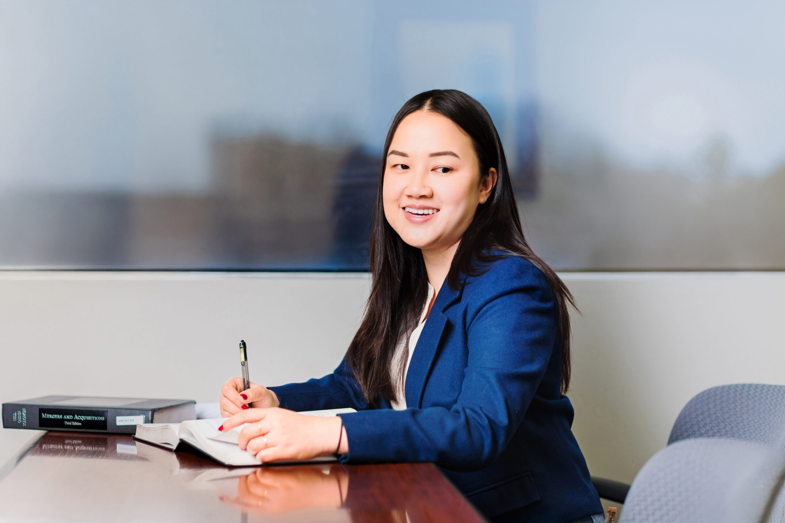 Student Truc Nguyen smiles as she writes down notes in her book.