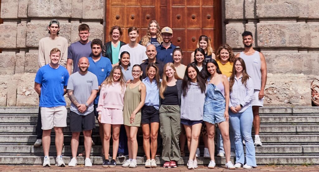 Students take a group photo in front of an international building.
